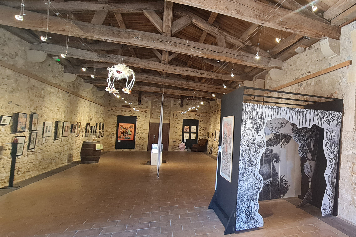Exposition 2025 Le club des monstres-artiste Jessie Désolée Belle salle d’exposition au charme patrimonial, avec charpente en bois et œuvres contemporaines mises en valeur dans un cadre authentique.